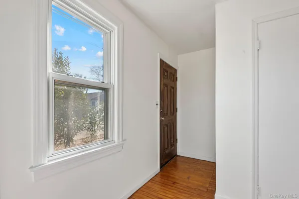 a view of a hallway with wooden floor and a large window