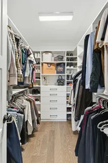 a view of walk in closet with clothes and shoes