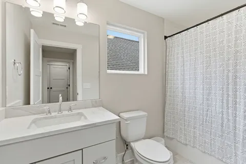 a bathroom with a sink a toilet and shower curtain