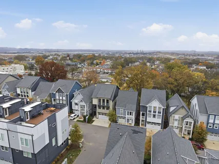 an aerial view of residential houses with outdoor space and ocean view