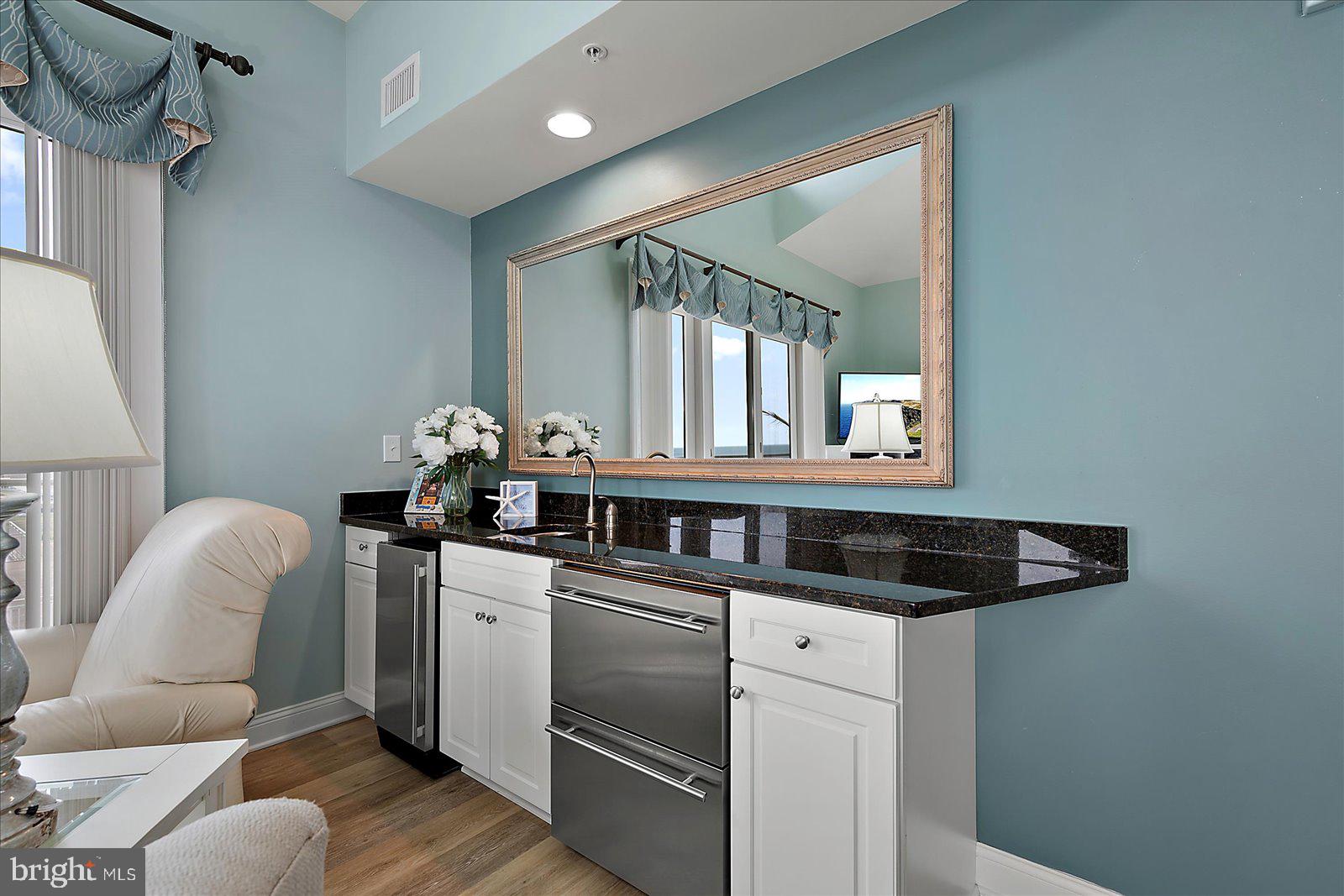 121 81st Street, Unit 907 Ocean City, MD 21842 - Photo 15 of 73 a kitchen with stainless steel appliances granite countertop a white cabinets and a wooden floor