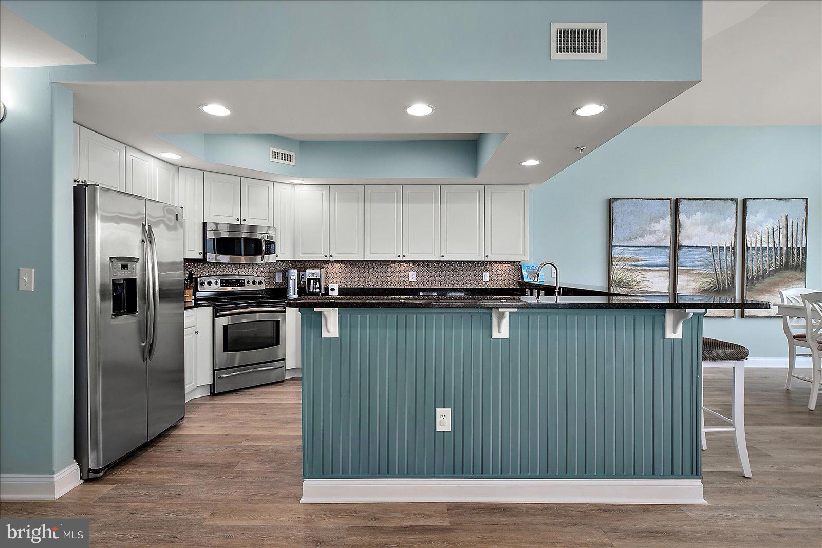 121 81st Street, Unit 907 Ocean City, MD 21842 - Photo 19 of 73 a kitchen with stainless steel appliances granite countertop a refrigerator a stove a sink and a microwave