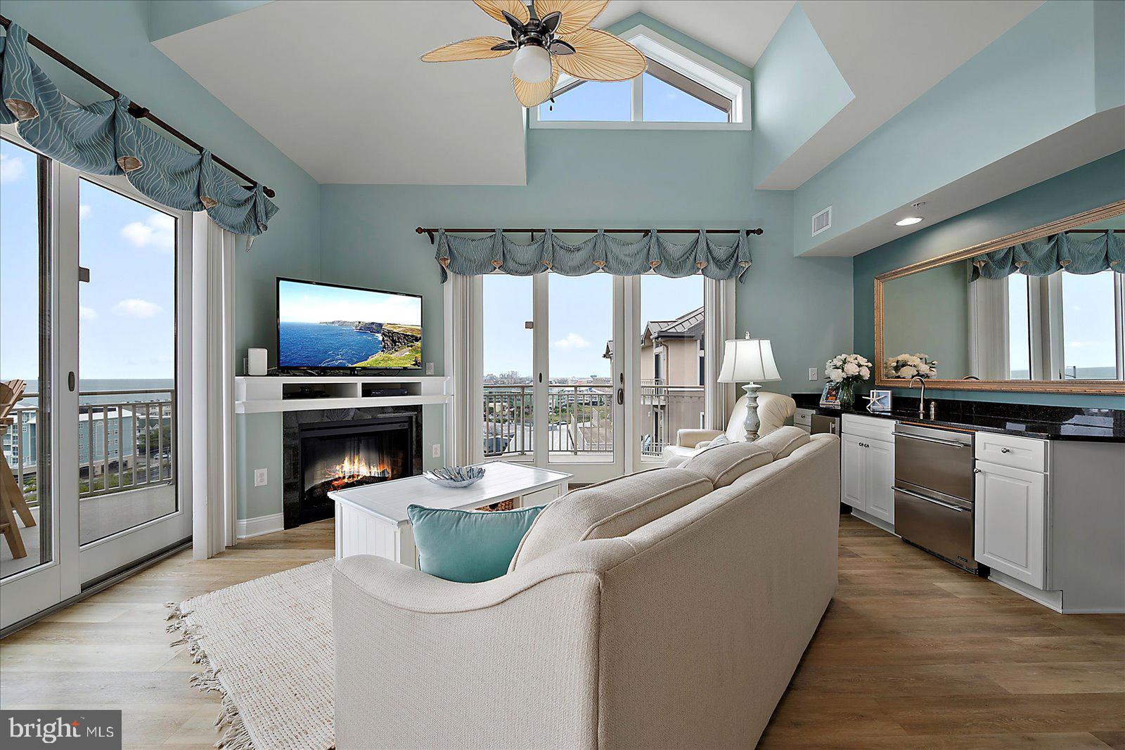 121 81st Street, Unit 907 Ocean City, MD 21842 - Photo 7 of 73 a living room with furniture a floor to ceiling window and kitchen view