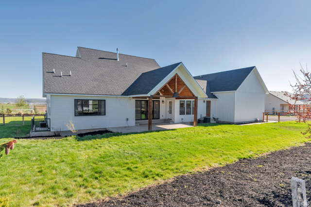 1820 West Farmhouse Flats Road Peoa, UT 84061 - Photo 58 of 79 Rear exterior showcasing a covered patio with exposed wood beams and columns, white siding, and black-framed windows