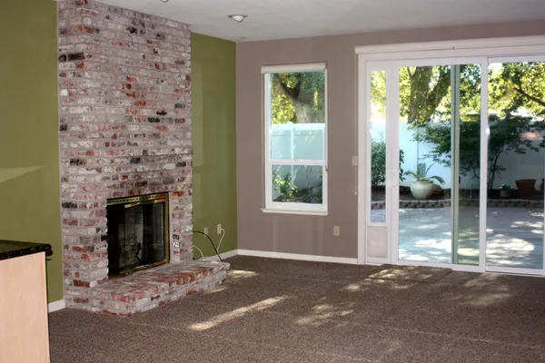 a living room with a fireplace and a large window