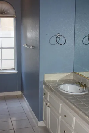 a bathroom with a granite countertop sink and a mirror
