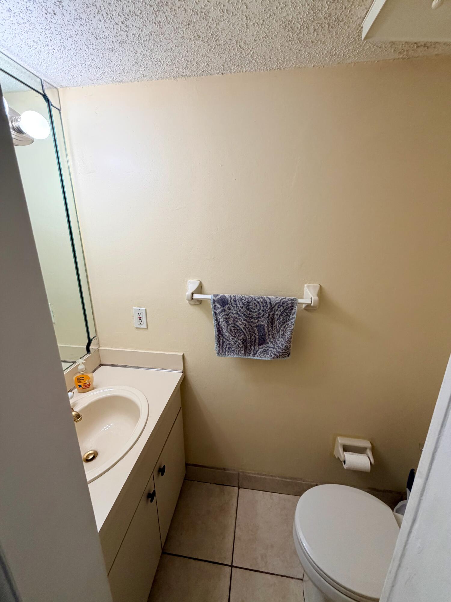 11071 Northwest 7th Street, Unit 104 Miami, FL 33172 - Photo 13 of 30 a bathroom with a sink a toilet and a mirror
