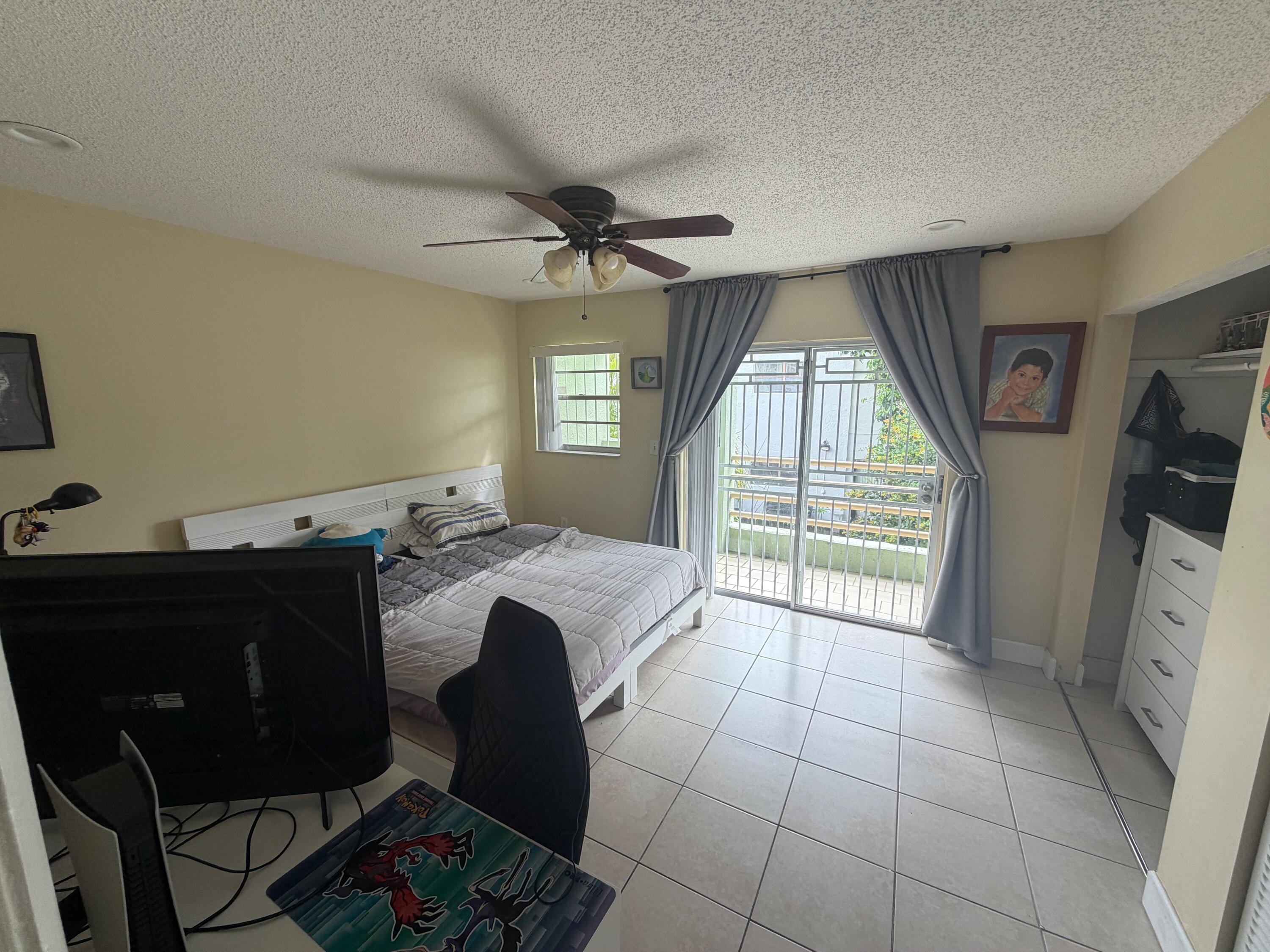 11071 Northwest 7th Street, Unit 104 Miami, FL 33172 - Photo 18 of 30 a spacious bedroom with a bed and a flat screen tv
