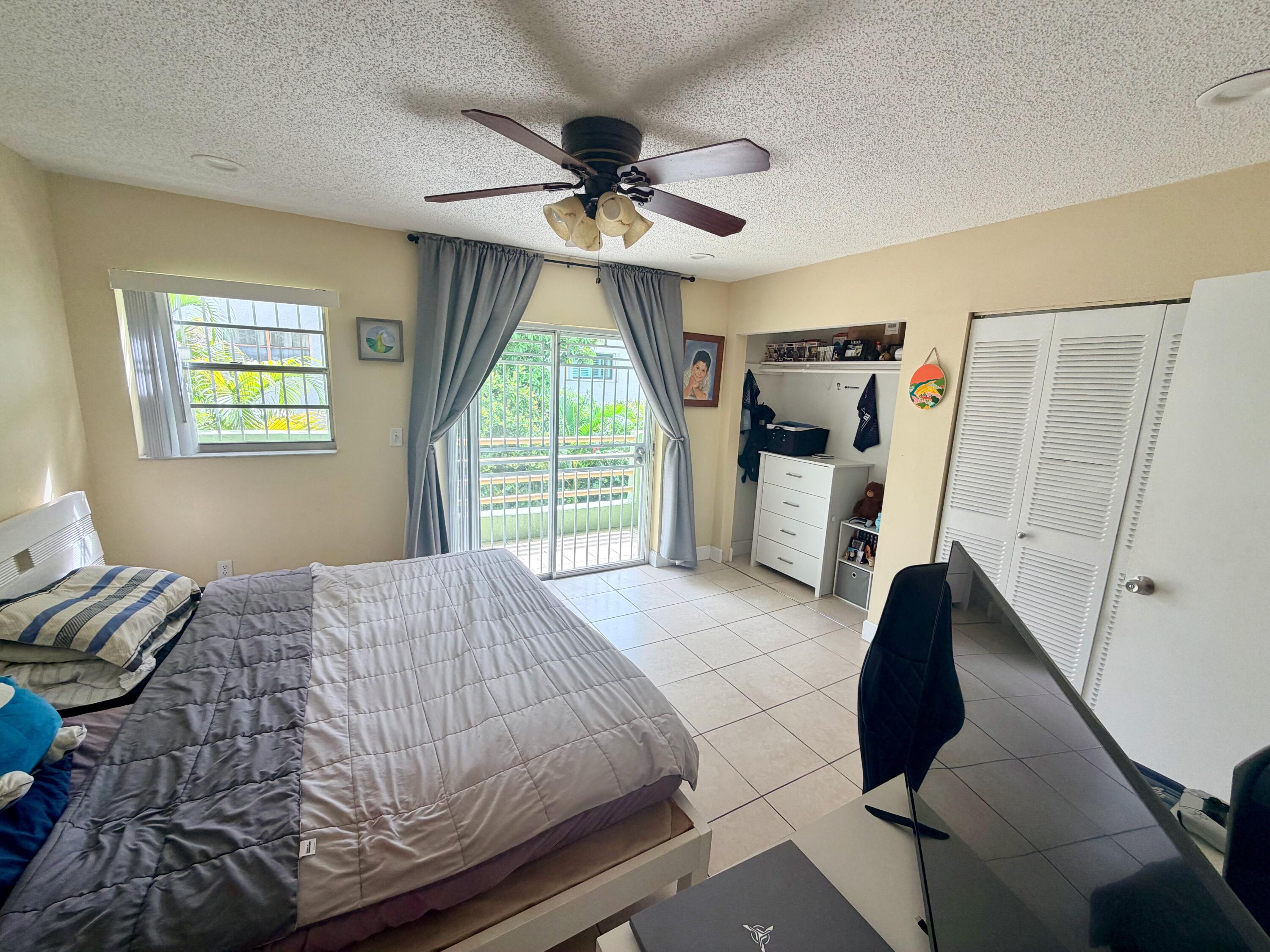11071 Northwest 7th Street, Unit 104 Miami, FL 33172 - Photo 19 of 30 a bedroom with a bed and a chandelier