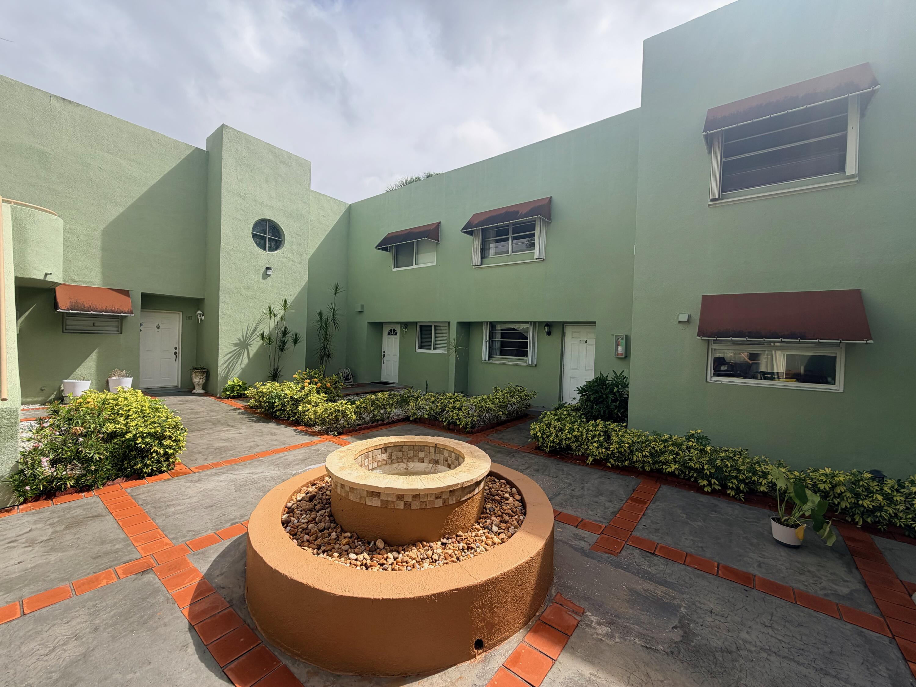 11071 Northwest 7th Street, Unit 104 Miami, FL 33172 - Photo 2 of 30 a view of a house with backyard sitting area and fire pit