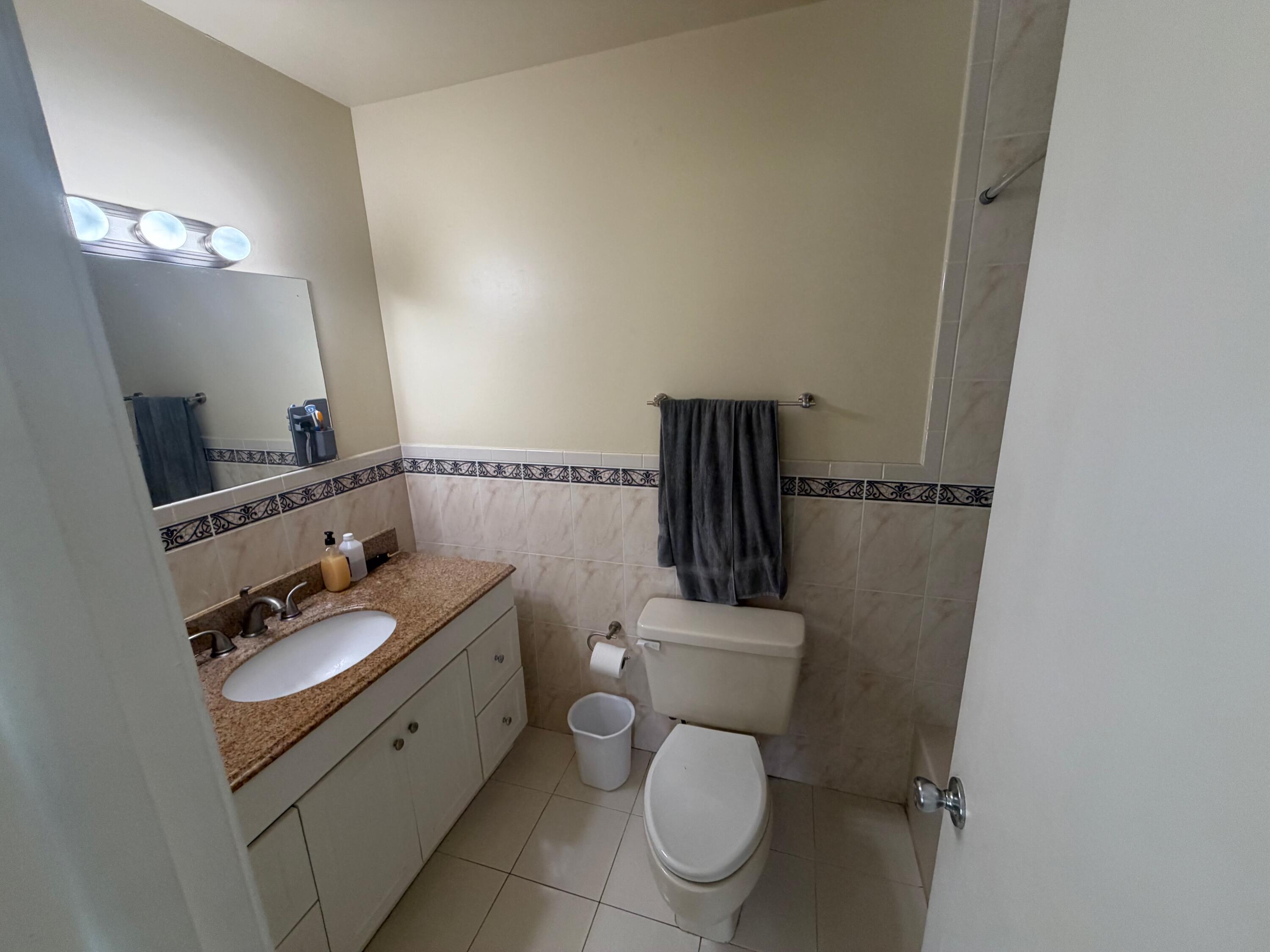 11071 Northwest 7th Street, Unit 104 Miami, FL 33172 - Photo 21 of 30 a bathroom with a toilet sink and mirror