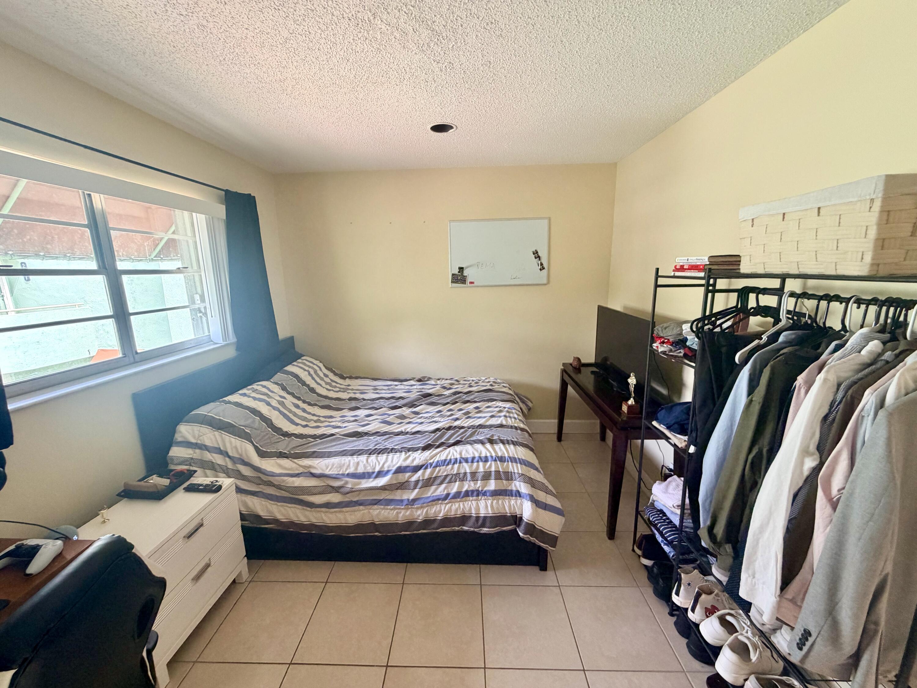 11071 Northwest 7th Street, Unit 104 Miami, FL 33172 - Photo 26 of 30 a bedroom with a bed and a window