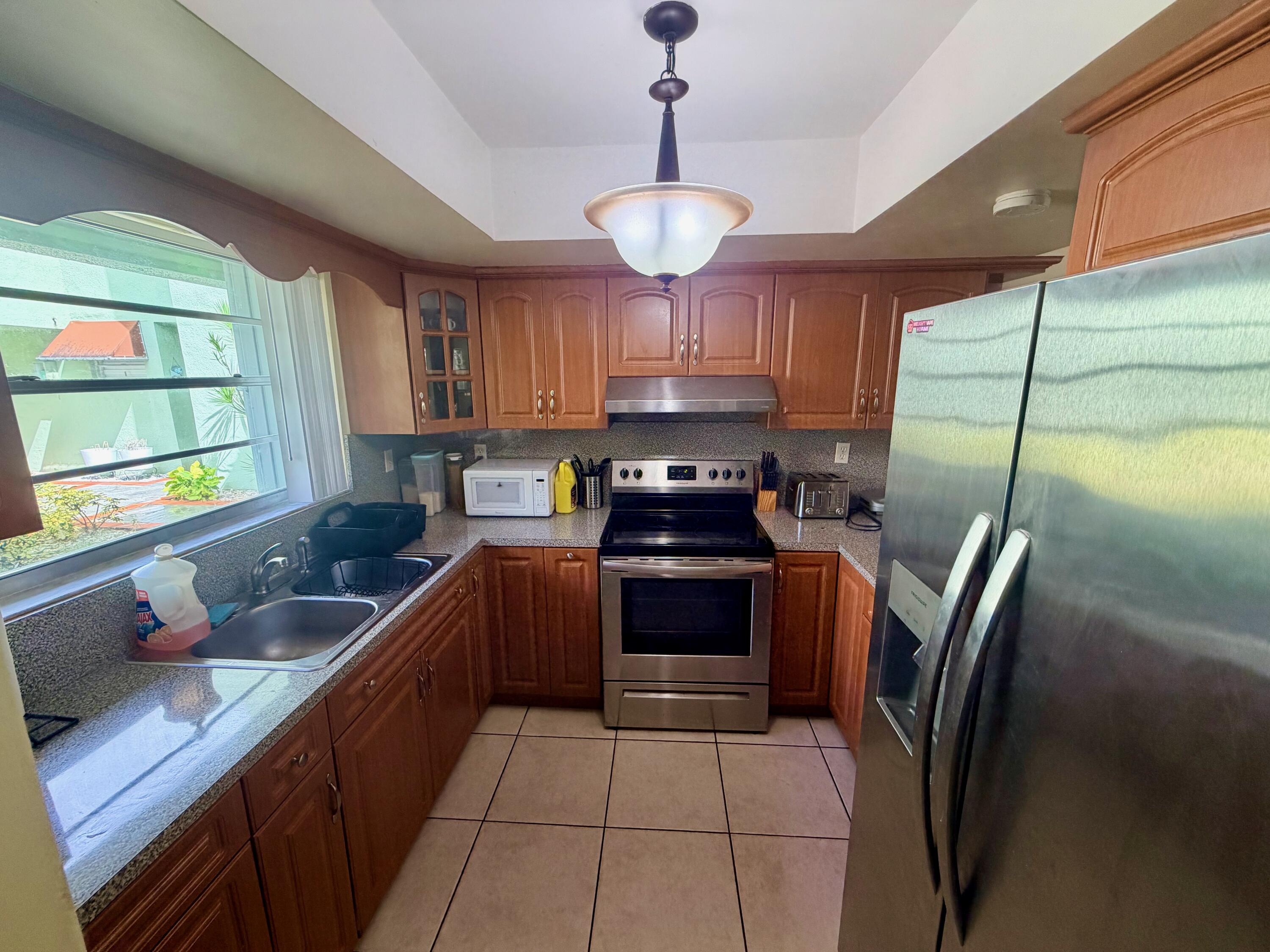 11071 Northwest 7th Street, Unit 104 Miami, FL 33172 - Photo 5 of 30 a kitchen with stainless steel appliances granite countertop a sink a stove and a refrigerator