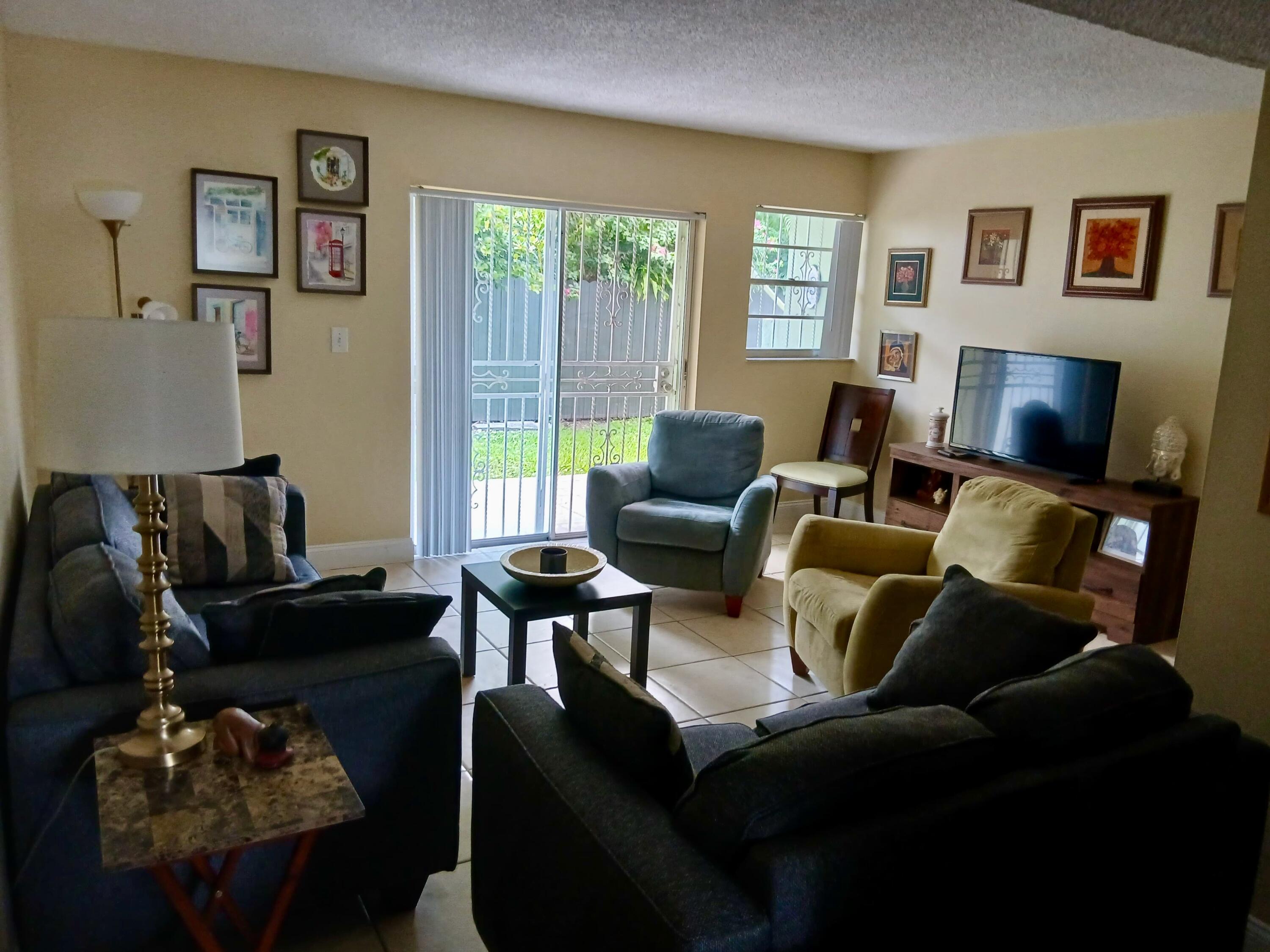 11071 Northwest 7th Street, Unit 104 Miami, FL 33172 - Photo 7 of 30 a living room with furniture and a floor to ceiling window