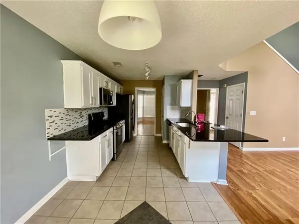 a large white kitchen with a large counter top and stainless steel appliances