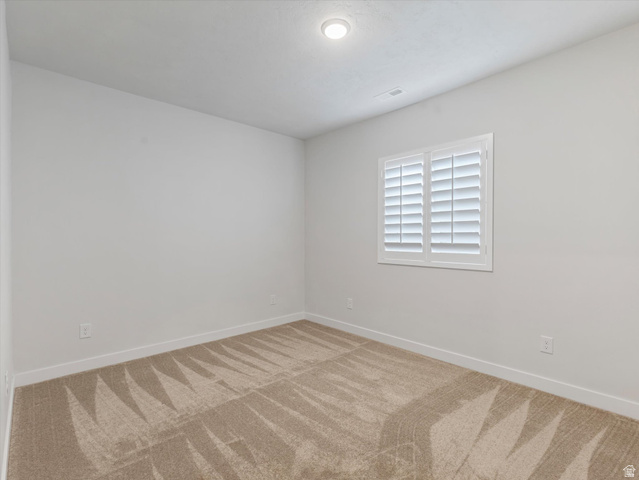 11759 South Watercourse Road South Jordan, UT 84009 - Photo 20 of 33 Neutral-toned room featuring a window with white plantation shutters, white walls, and light-colored carpet flooring