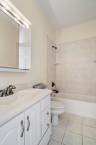 a bathroom with a double vanity sink and mirror with bathtub