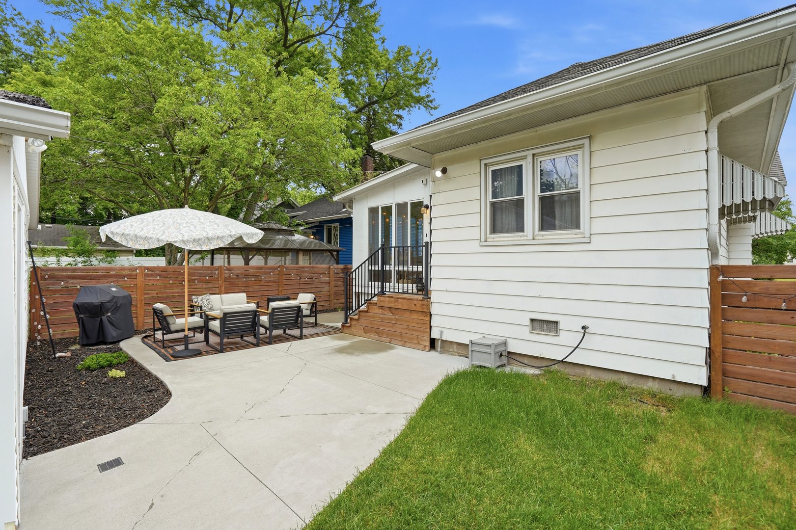 2431 14th Avenue Moline, IL 61265 - Photo 23 of 37 a backyard of a house with table and chairs under an umbrella