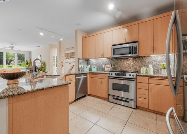 a kitchen with stainless steel appliances granite countertop a sink and a stove