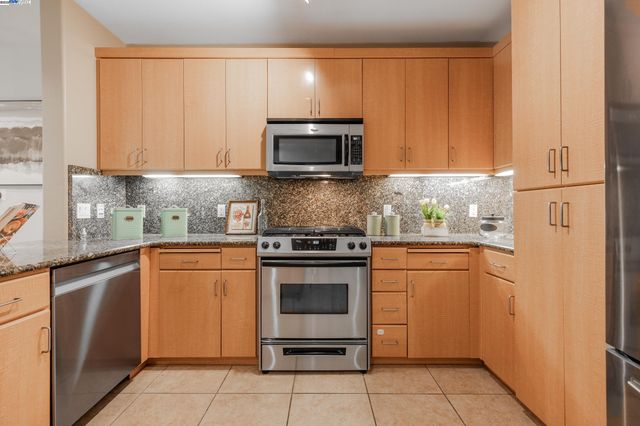 a kitchen with stainless steel appliances granite countertop a refrigerator stove and sink