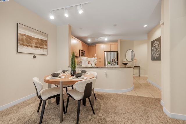 a dining area with a table chairs and a refrigerator
