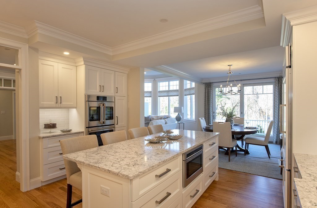 6 Robert Drive, Unit 23 Andover, MA 01810 - Photo 10 of 21 a large kitchen with kitchen island a large counter space a sink appliances and living room view