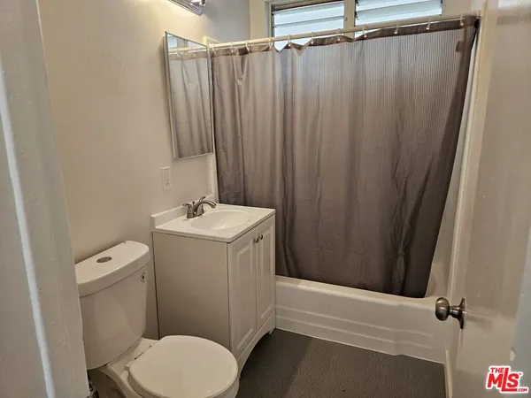 a bathroom with a sink a toilet a mirror and shower