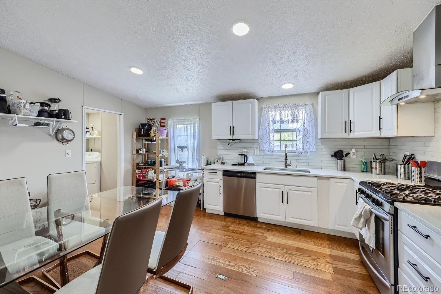 11682 Frederick Street Fort Lupton, CO 80621 - Photo 3 of 11 a kitchen with granite countertop a sink cabinets and stainless steel appliances