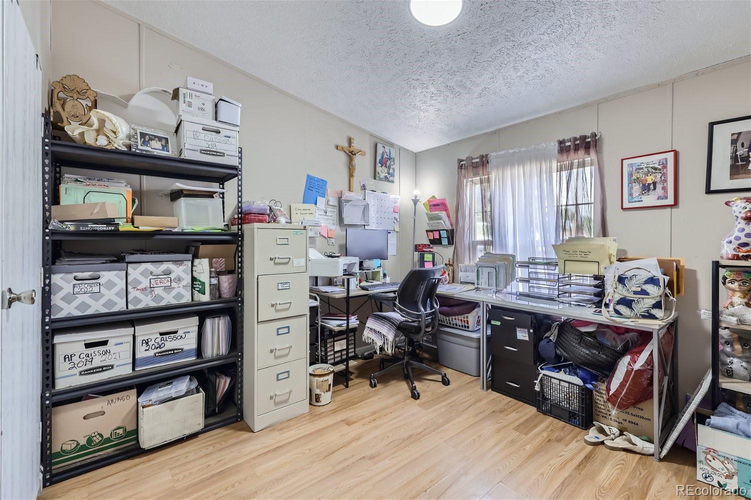 11682 Frederick Street Fort Lupton, CO 80621 - Photo 5 of 11 a view of a workspace with furniture and a window