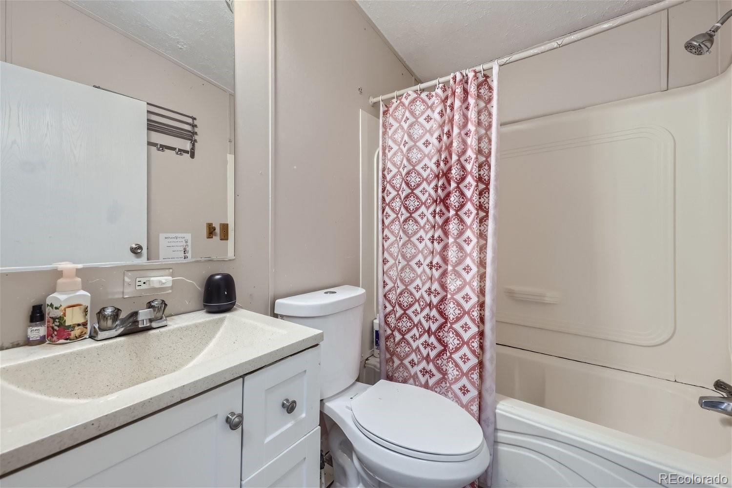 11682 Frederick Street Fort Lupton, CO 80621 - Photo 6 of 11 a bathroom with a sink toilet and shower