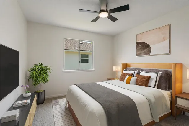 a bedroom with bed and a potted plant