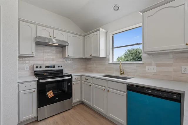 a kitchen with a sink stove and cabinets