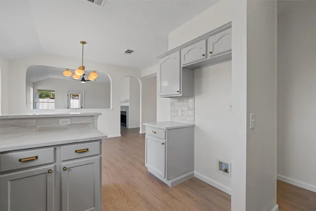 a kitchen with white cabinets and a chandelier