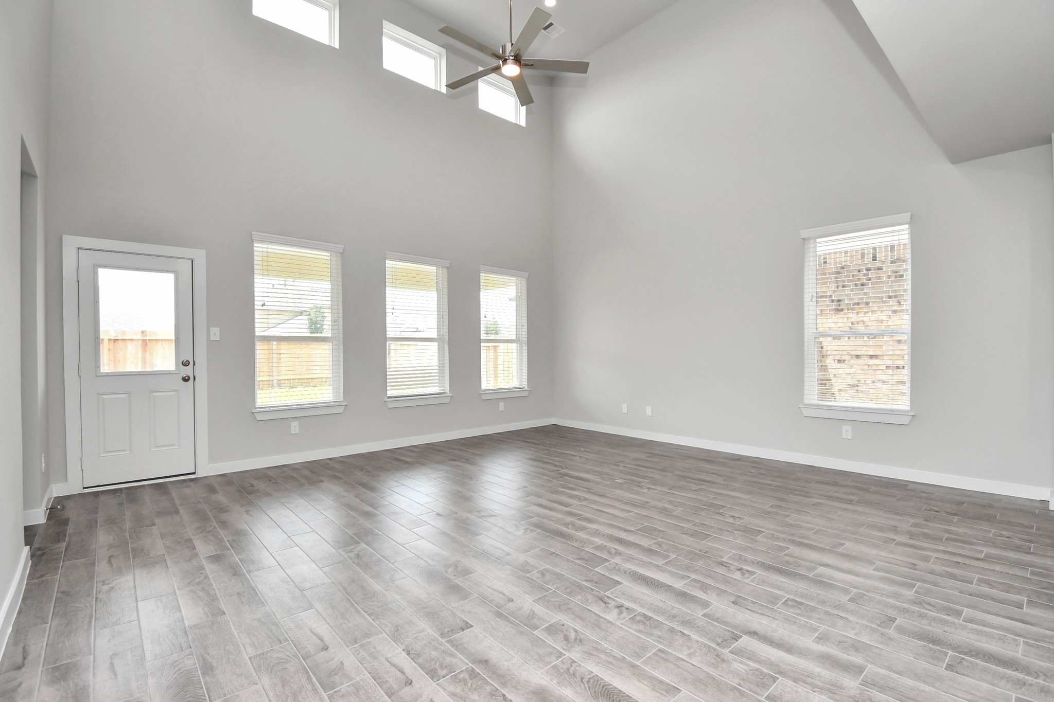 15806 Telge Ridge Lane Cypress, TX 77429 - Photo 22 of 40 an empty room with wooden floor chandelier fan and windows