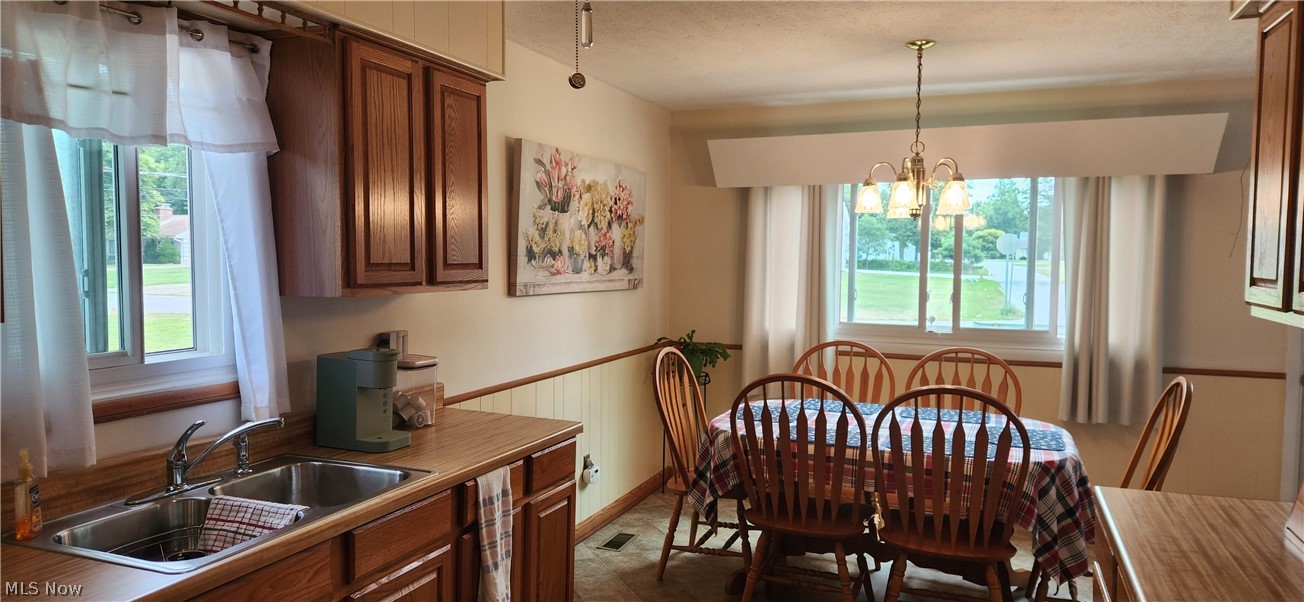 5852 Lake Road Mentor, OH 44060 - Photo 11 of 45 Tiled dining room with sink, a wealth of natural light, and a chandelier