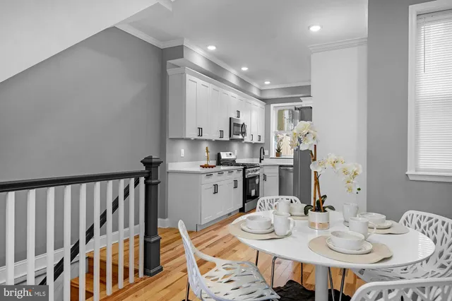 a kitchen with stainless steel appliances kitchen island granite countertop a stove a sink a dining table and chairs