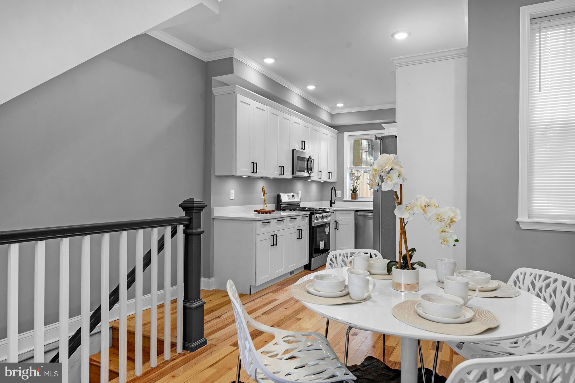 1908 East Lanvale Street Baltimore, MD 21213 - Photo 12 of 49 a kitchen with stainless steel appliances kitchen island granite countertop a stove a sink a dining table and chairs