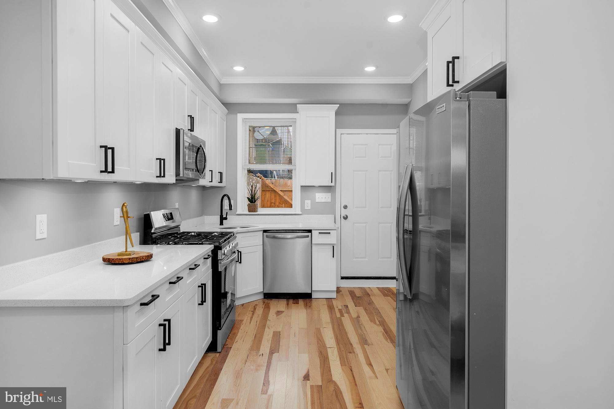 1908 East Lanvale Street Baltimore, MD 21213 - Photo 13 of 49 a kitchen with a white cabinets and refrigerator