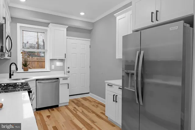 a kitchen with stainless steel appliances a refrigerator sink and cabinets