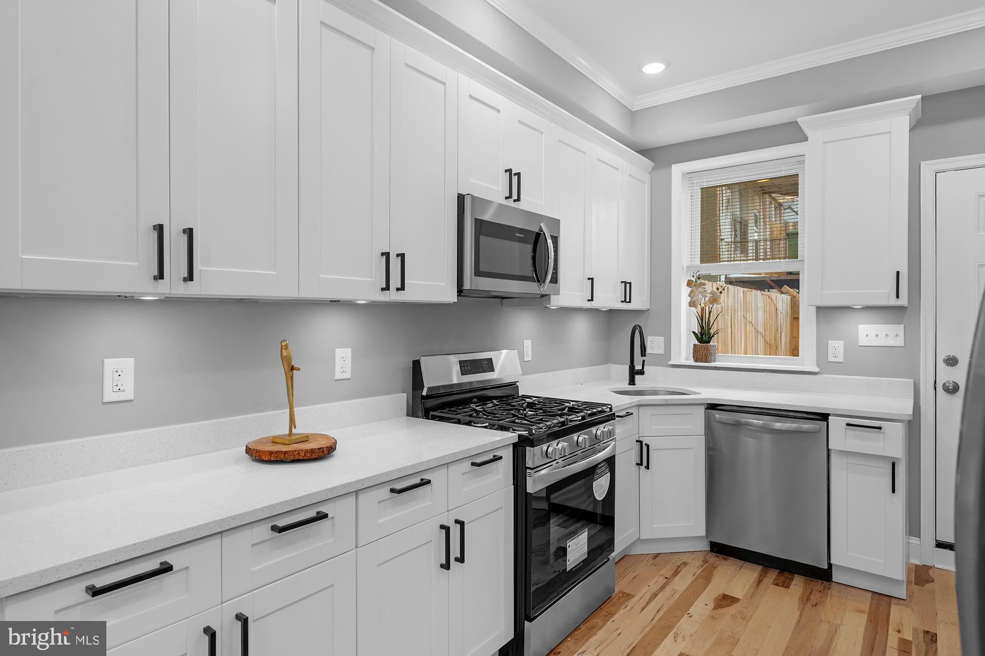 1908 East Lanvale Street Baltimore, MD 21213 - Photo 16 of 49 a kitchen with stainless steel appliances granite countertop a sink a stove and cabinets