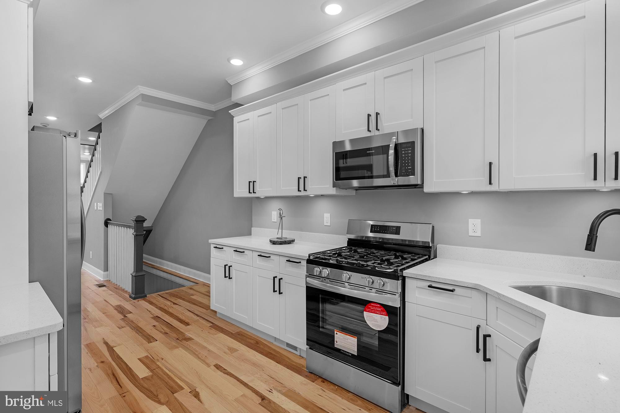 1908 East Lanvale Street Baltimore, MD 21213 - Photo 18 of 49 a kitchen with stainless steel appliances granite countertop a stove a sink and a microwave