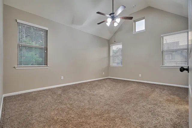 an empty room with windows and fan