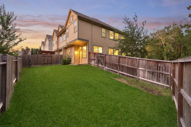 a view of a house with a yard and wooden fence