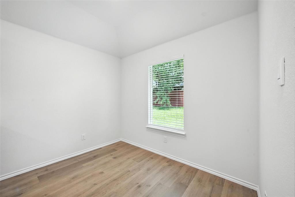 405 Regiment Road Sherman, TX 75090 - Photo 8 of 22 an empty room with wooden floor and a window