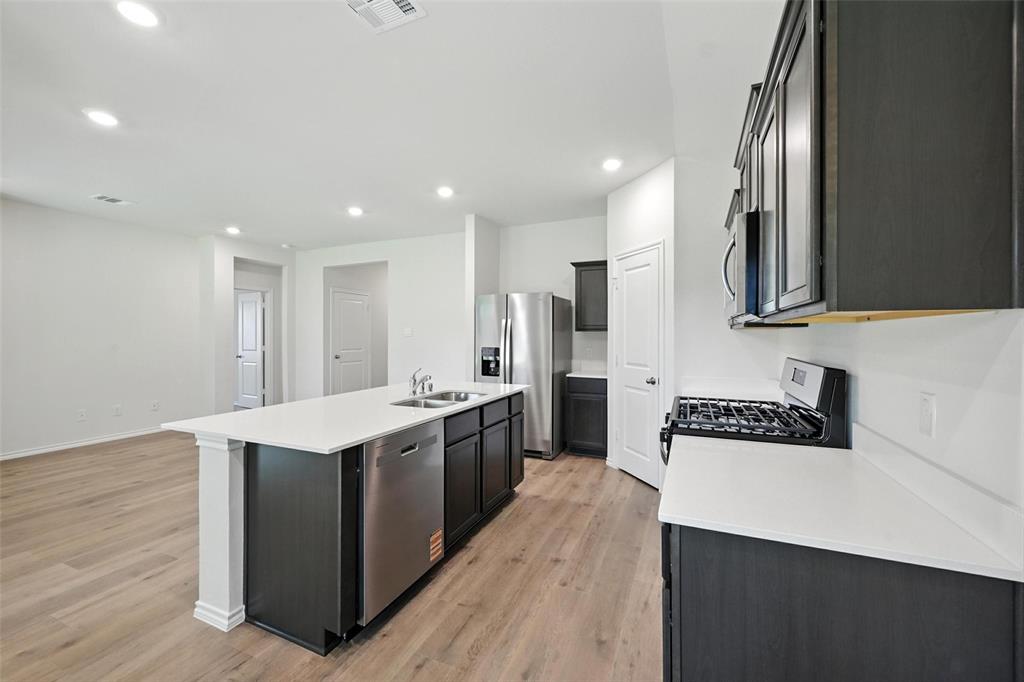 405 Regiment Road Sherman, TX 75090 - Photo 2 of 22 a kitchen with stainless steel appliances a sink a stove a refrigerator cabinets and wooden floor