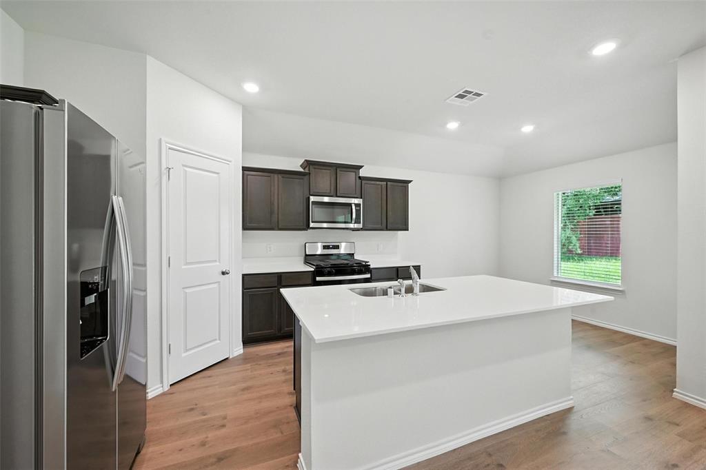 405 Regiment Road Sherman, TX 75090 - Photo 4 of 22 a kitchen with a refrigerator a stove top oven a sink dishwasher and wooden floor