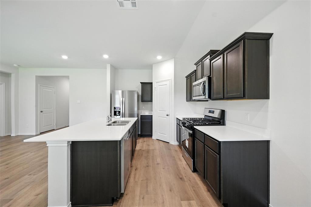 405 Regiment Road Sherman, TX 75090 - Photo 6 of 22 a kitchen with stainless steel appliances granite countertop a sink stove refrigerator and cabinets