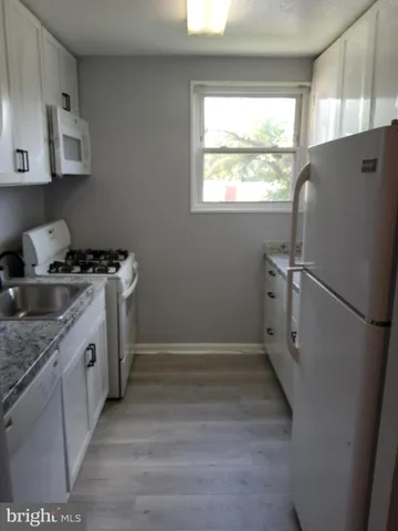 a kitchen with a stove a refrigerator and a sink
