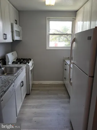 a kitchen with a stove a refrigerator and a sink