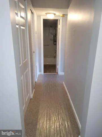 a view of a hallway with wooden floor and closet
